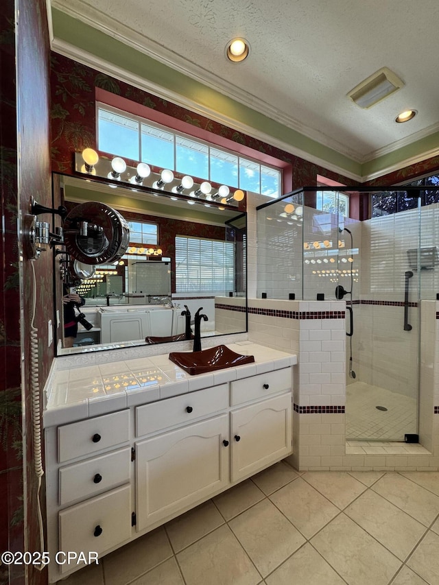 full bath featuring crown molding, tile patterned floors, a shower stall, and a textured ceiling