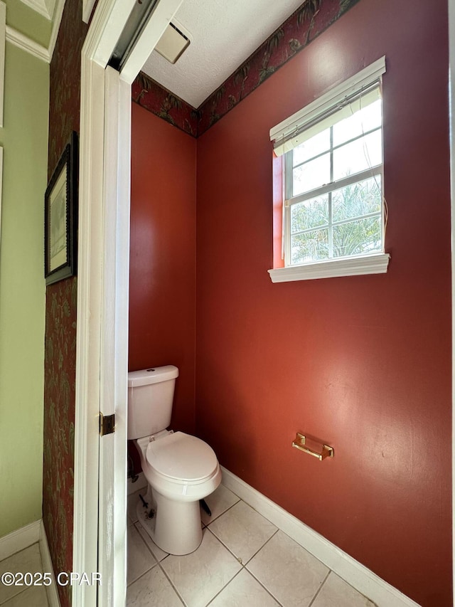 bathroom with tile patterned flooring, toilet, and baseboards