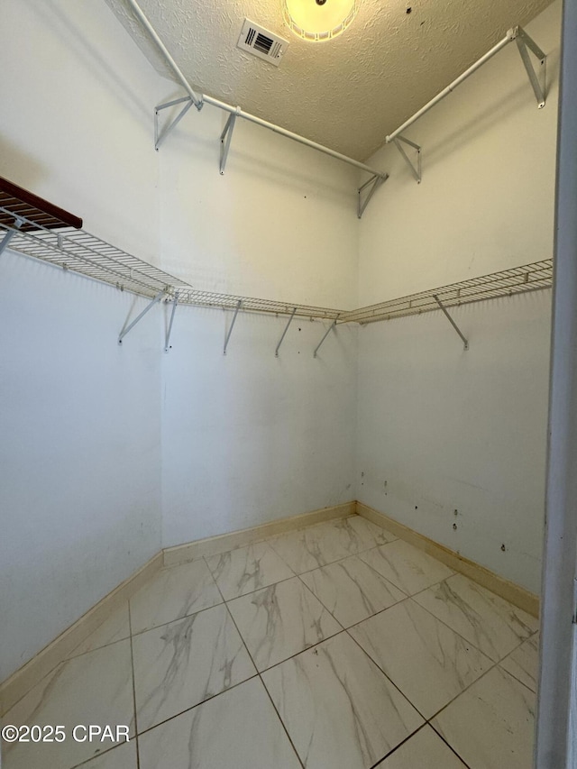 spacious closet with visible vents and marble finish floor