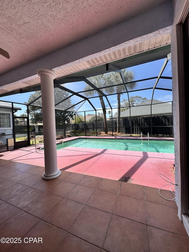 pool with glass enclosure, fence, and a patio area