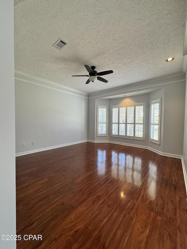 unfurnished room featuring visible vents, baseboards, wood finished floors, and ornamental molding