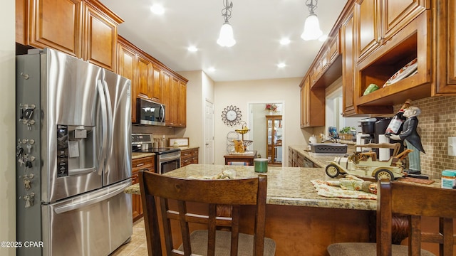 kitchen with tasteful backsplash, a breakfast bar, light stone counters, a peninsula, and stainless steel appliances