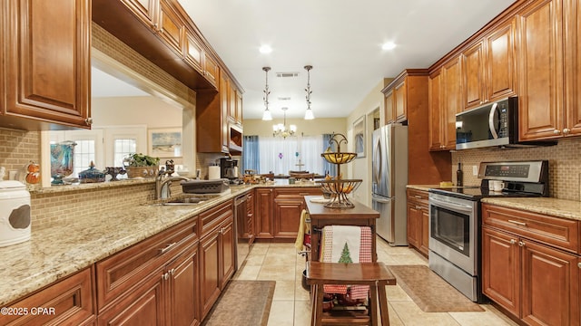 kitchen featuring visible vents, light stone counters, decorative backsplash, an inviting chandelier, and stainless steel appliances