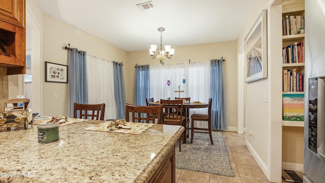 dining space featuring light tile patterned floors, visible vents, baseboards, and a chandelier