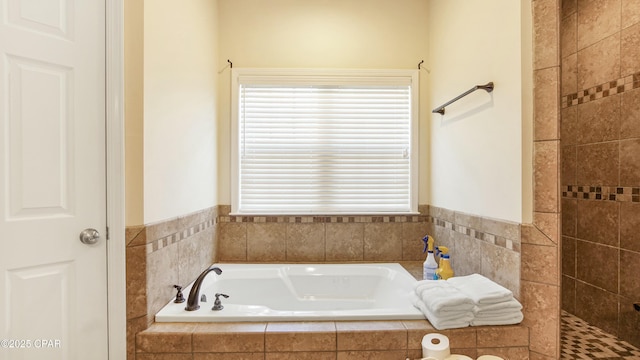 full bathroom with a bath and a tile shower