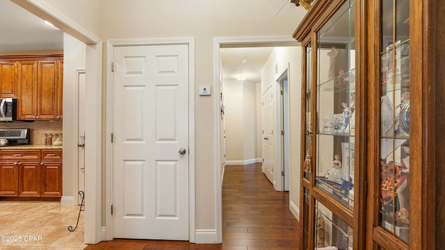 corridor with light wood-style flooring and baseboards