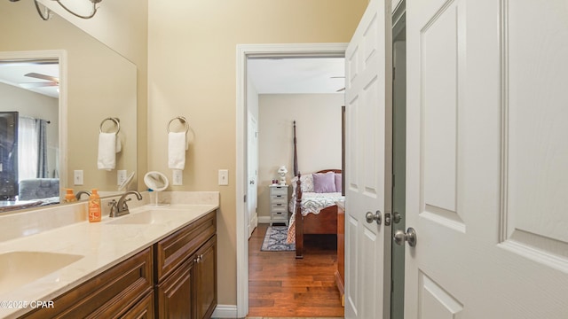 full bath featuring ensuite bathroom, a sink, wood finished floors, double vanity, and ceiling fan