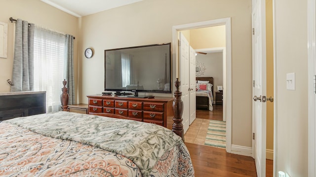 bedroom with baseboards and wood finished floors