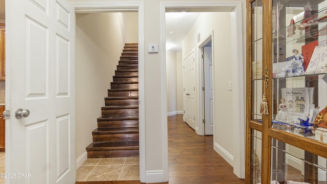 staircase with wood finished floors and baseboards