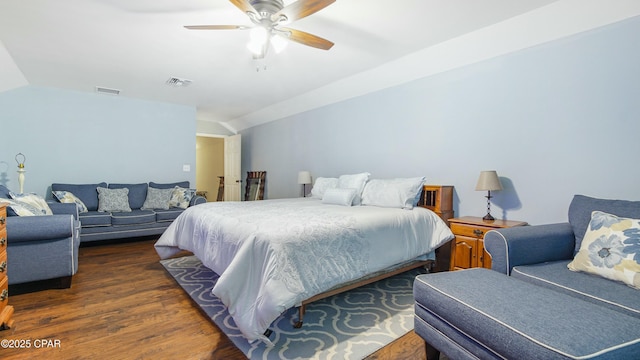 bedroom with a ceiling fan, vaulted ceiling, wood finished floors, and visible vents