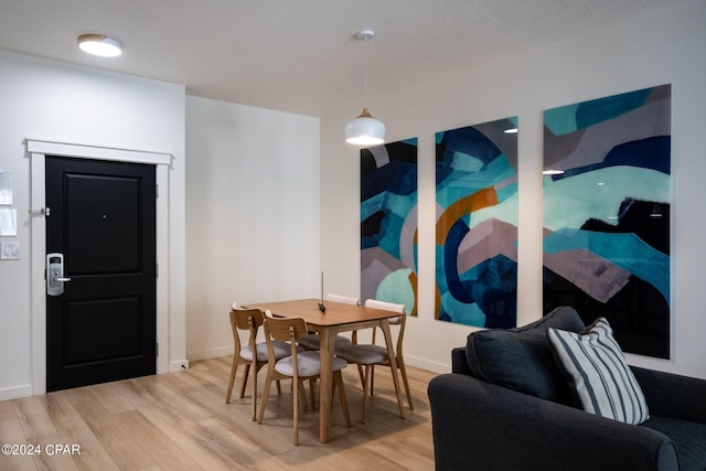dining space with baseboards and light wood-style floors