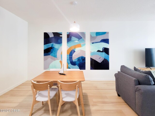 dining area featuring light wood-style floors and baseboards