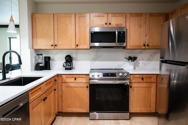 kitchen with stainless steel appliances, light countertops, and a sink