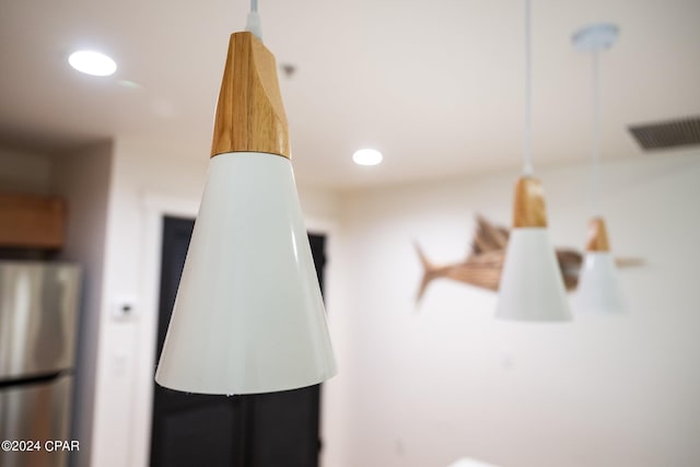 interior details with visible vents, freestanding refrigerator, and recessed lighting