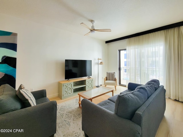 living room with wood finished floors, baseboards, and ceiling fan