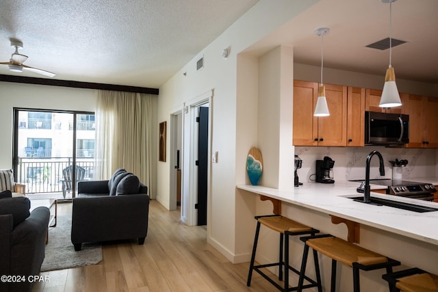 living room featuring light wood-type flooring, baseboards, visible vents, and ceiling fan