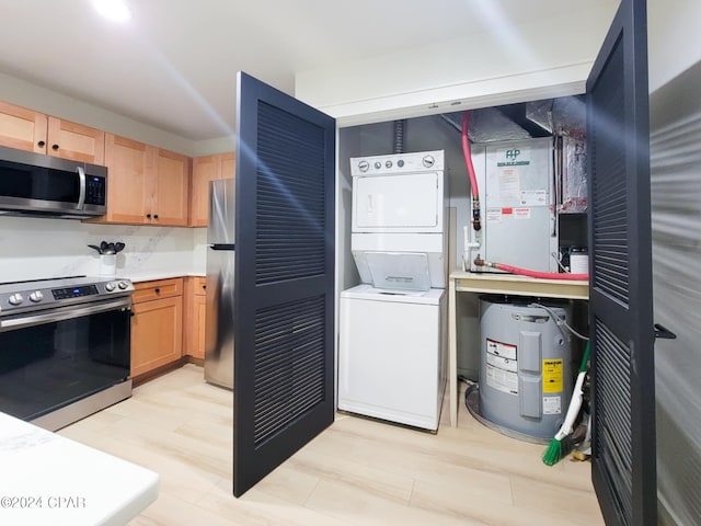 interior space with light brown cabinetry, water heater, light countertops, stacked washing maching and dryer, and appliances with stainless steel finishes