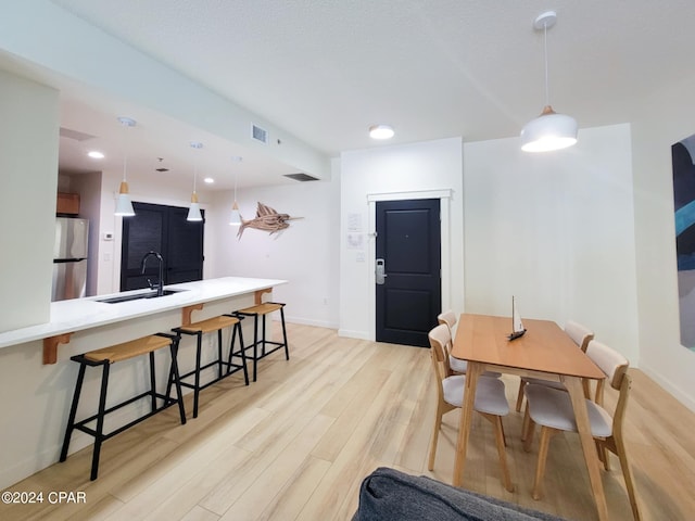 dining room with light wood finished floors, baseboards, and visible vents