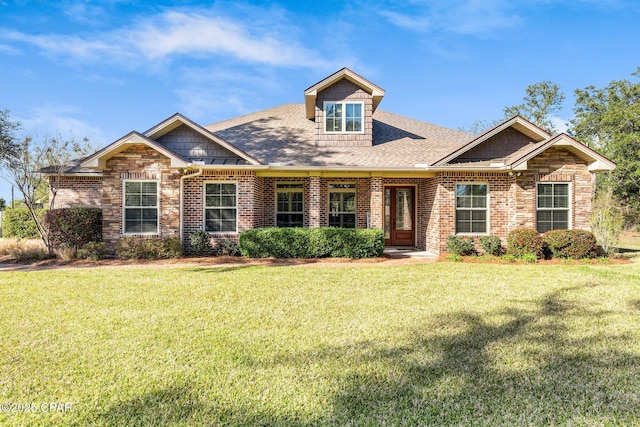 craftsman inspired home featuring stone siding, brick siding, a front lawn, and a shingled roof