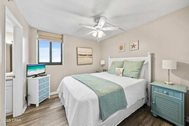 bedroom featuring baseboards, dark wood-type flooring, ceiling fan, and a textured ceiling