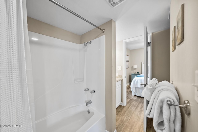 bathroom featuring connected bathroom, visible vents, wood finished floors, and shower / bath combination with curtain