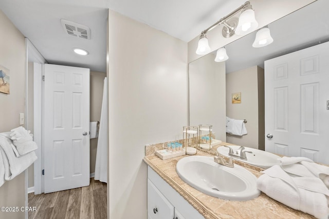 bathroom featuring visible vents, wood finished floors, and vanity