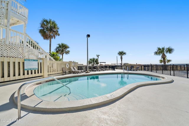 community pool with stairway, a patio, and fence