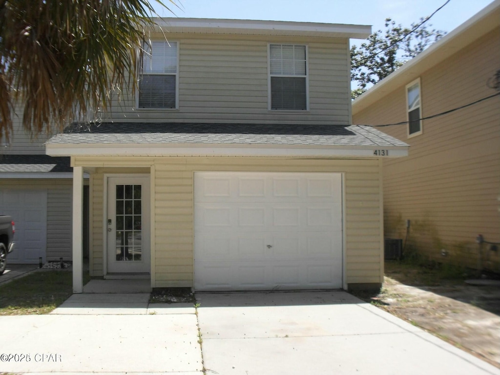 view of front of property featuring an attached garage, roof with shingles, and driveway