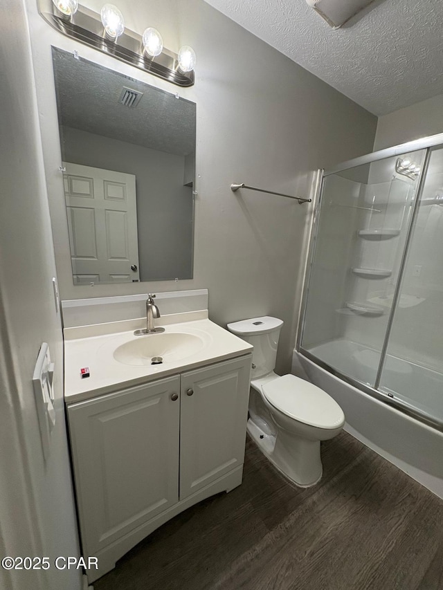 bathroom featuring vanity, toilet, visible vents, a textured ceiling, and wood finished floors
