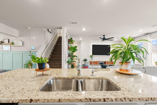 kitchen with light stone countertops, open floor plan, and a decorative wall