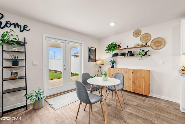 dining area featuring light wood-style flooring, french doors, and baseboards