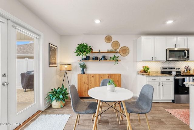 dining space with recessed lighting, baseboards, and light wood finished floors