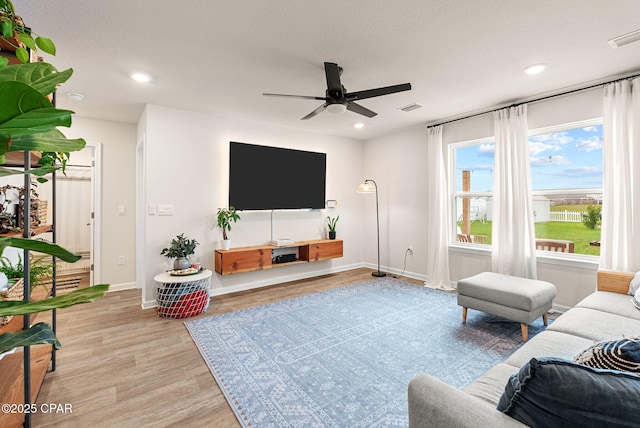 living area featuring recessed lighting, light wood-type flooring, and visible vents