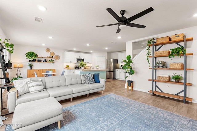 living room with light wood-style flooring, recessed lighting, visible vents, and ceiling fan