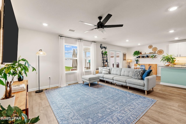 living room with visible vents, light wood finished floors, baseboards, recessed lighting, and ceiling fan