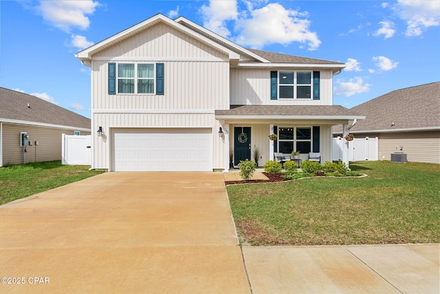 traditional-style house featuring fence, a front yard, driveway, an attached garage, and a gate