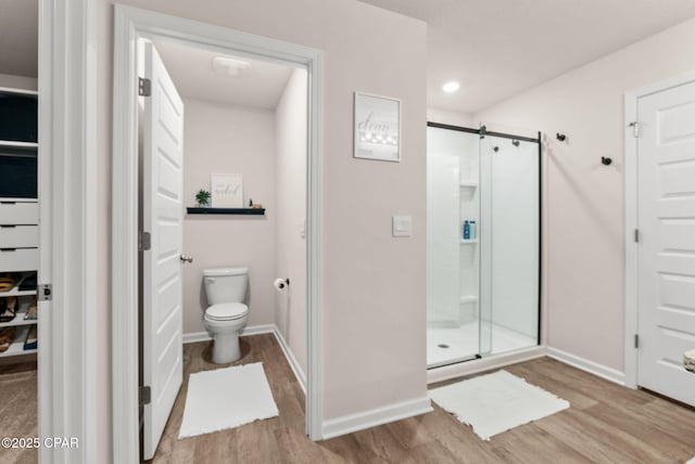 full bathroom with baseboards, toilet, recessed lighting, a stall shower, and wood finished floors