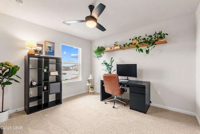 carpeted home office with baseboards and a ceiling fan