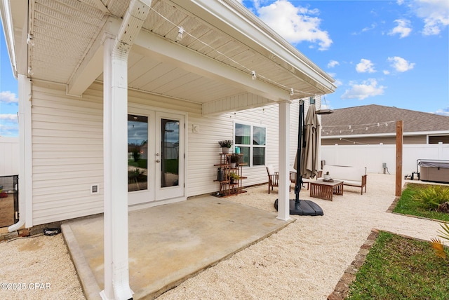 view of patio with an outdoor living space, french doors, a hot tub, and fence