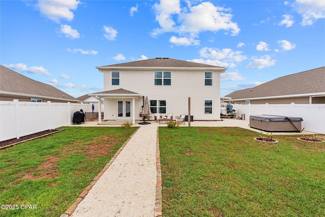 back of property with a lawn, a patio, a fenced backyard, french doors, and a hot tub