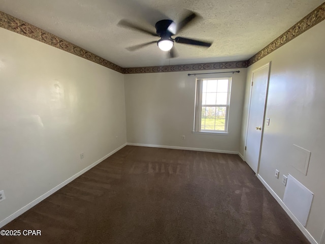 spare room featuring ceiling fan, a textured ceiling, baseboards, and dark colored carpet