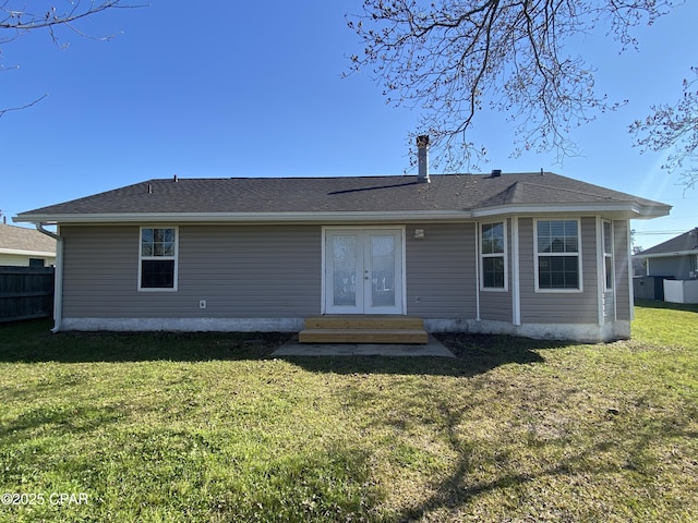 back of property with a yard, entry steps, french doors, and fence