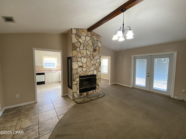 unfurnished living room featuring visible vents, lofted ceiling with beams, light tile patterned floors, light carpet, and a fireplace