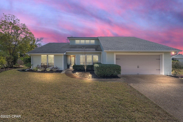 view of front of home with a front yard, an attached garage, driveway, and roof with shingles