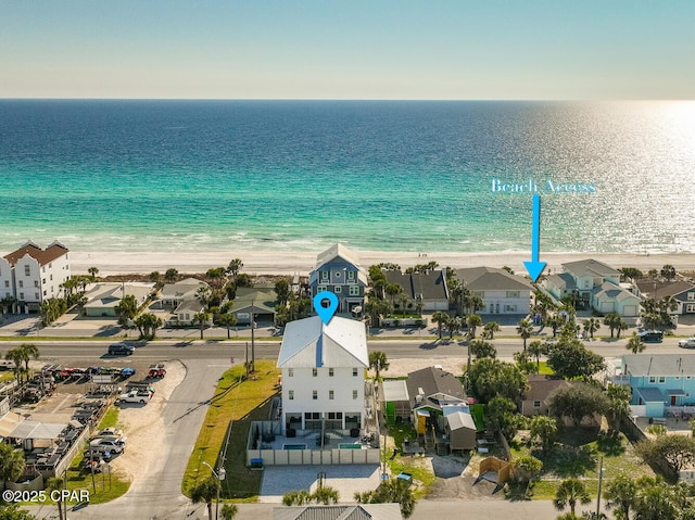 drone / aerial view with a residential view, a water view, and a beach view