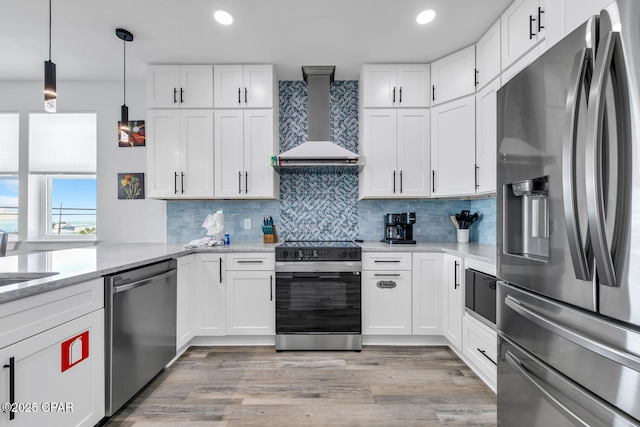 kitchen with white cabinets, stainless steel appliances, and wall chimney range hood