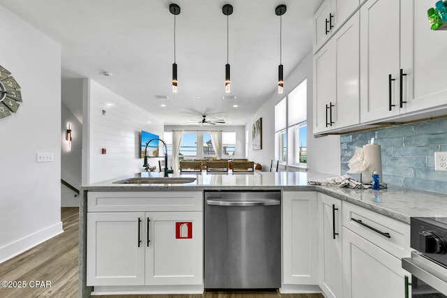 kitchen with light wood finished floors, light stone countertops, dishwasher, a peninsula, and a sink