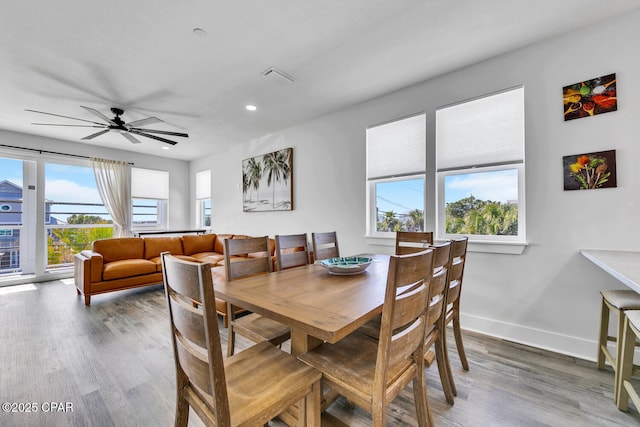 dining area with visible vents, a healthy amount of sunlight, baseboards, and wood finished floors