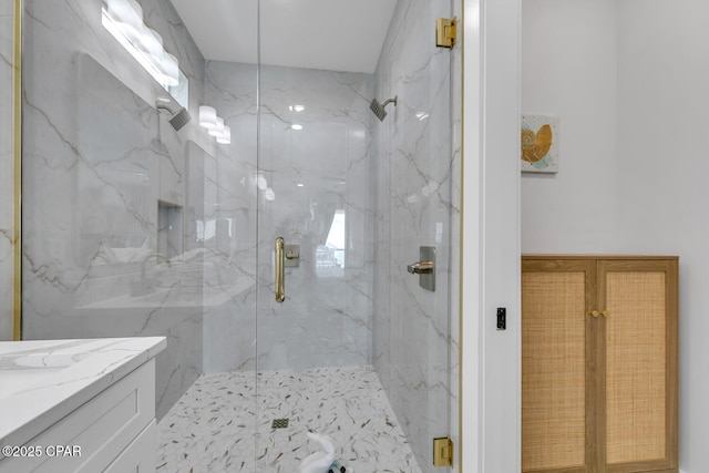 bathroom featuring vanity and a marble finish shower