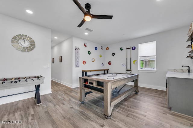 playroom featuring a ceiling fan, baseboards, visible vents, light wood finished floors, and a sink